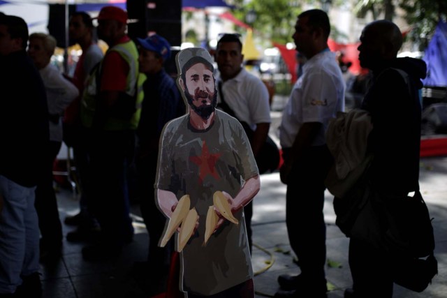 A cardboard cut-out of Cuba's late President Fidel Castro is seen as people wait to apply for a card that will register them for government social programmes, in Caracas, Venezuela January 20, 2017. REUTERS/Marco Bello