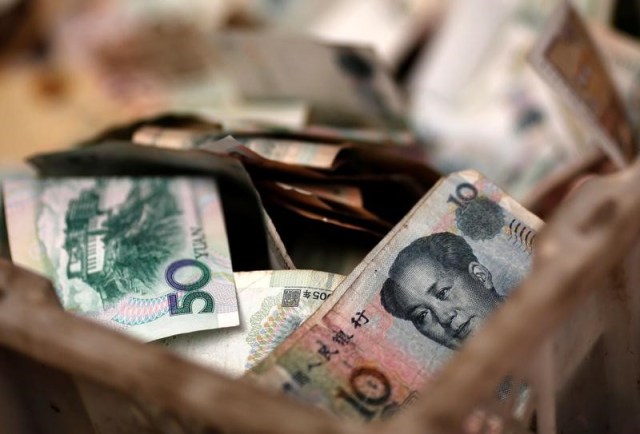En la imagen, billetes chinos en la caja de cambio de un vendedor en un mercado de Pekín (Foto REUTERS/Kim Kyung-Hoon)