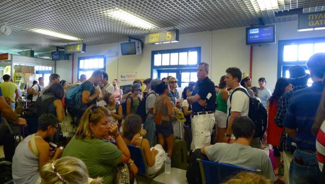 Pasajeros esperando ante las puertas de embarque en el aeropuerto de Santorini P. R. C