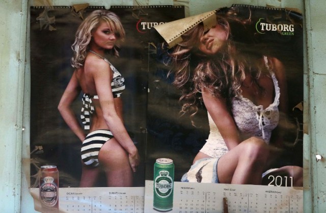 Pages of a calendar bearing images of woman advertising beer are seen on the wall of the alcohol shop of Wissam Ghanem, an Iraqi man from the Yazidi community, in the Iraqi town of Bashiqa, some 20 kilometres north east of Mosul, on February 17, 2017. Ghanem, who returned to the town of Bashiqa after Kurdish Peshmerga forces retook the town from Islamic State (IS) group jihadists, re-opened his alcohol business which was strictly forbidden under the rule of the Islamists, after finding cans of beer and bottles of spirits in abandoned houses formerly occupied by IS fighters. / AFP PHOTO / SAFIN HAMED