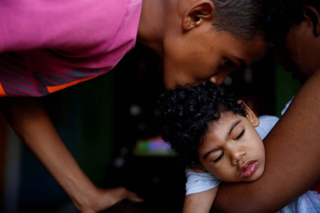 Isai Rocha (L), 14, kisses his brother Kaleth Heredia, 2, neurological patient being treated with anticonvulsants, before going out, at their house in Caracas, Venezuela January 31, 2017. REUTERS/Carlos Garcia Rawlins    SEARCH "EPILEPSY CARACAS" FOR THIS STORY. SEARCH "WIDER IMAGE" FOR ALL STORIES.