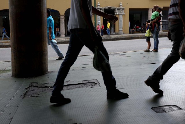 Norymar Torres (R), holds the hand of her son Lorenzo, 5, and carries her son Leonardo, 6, who is a neurological patient being treated with anticonvulsants, while they wait for transportation on the street in Caracas, Venezuela January 24, 2017. REUTERS/Carlos Garcia Rawlins   SEARCH "EPILEPSY CARACAS" FOR THIS STORY. SEARCH "WIDER IMAGE" FOR ALL STORIES.