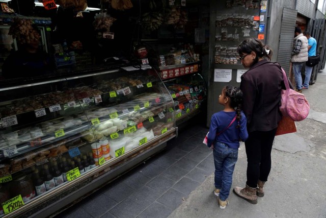 A woman and a child look at prices in a grocery store in downtown Caracas, Venezuela March 10, 2017. REUTERS/Marco Bello