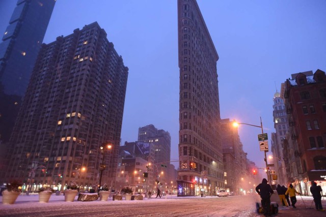 A man clears the sidewalk near Madison Square Park at the foot of the Flatiron building in Manhattan during a snowstorm in New York on March 14, 2017. Winter Storm Stella dumped snow and sleet Tuesday across the northeastern United States where thousands of flights were canceled and schools closed, but appeared less severe than initially forecast. After daybreak the National Weather Service (NWS) revised down its predicted snow accumulation for the city of New York, saying that the storm had moved across the coast. / AFP PHOTO / ERIC BARADAT