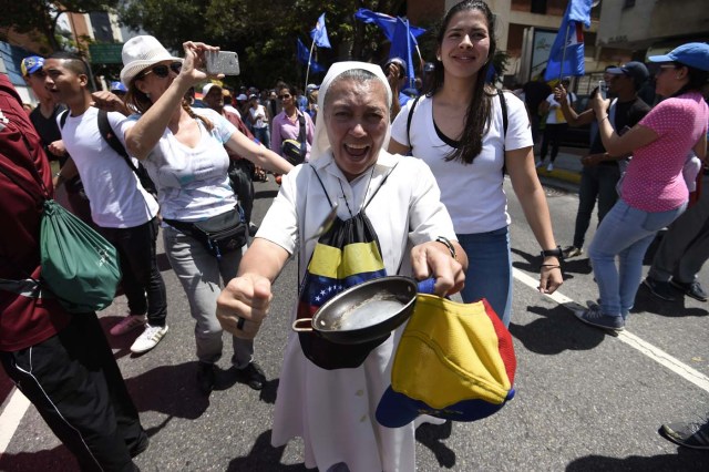 Venezuelan opposition activists shout slogans during a protest against the government of President Nicolas Maduro on April 6, 2017 in Caracas. The center-right opposition vowed fresh street protests -after earlier unrest left dozens of people injured - to increase pressure on Maduro, whom they blame for the country's economic crisis. / AFP PHOTO / JUAN BARRETO