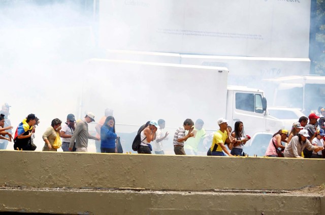 Demonstrators run away from tear gas during a rally against Venezuela's President Nicolas Maduro's government in Caracas, Venezuela April 10, 2017. REUTERS/Christian Veron