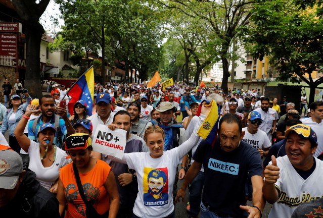 Lilian Tintori (C), a wife of jailed opposition leader Leopoldo Lopez, rallies during the so-called "mother of all marches" against Venezuela's President Nicolas Maduro carrying a sing that reads "No more dictatorship" in Caracas, Venezuela April 19, 2017. REUTERS/Carlos Garcia Rawlins