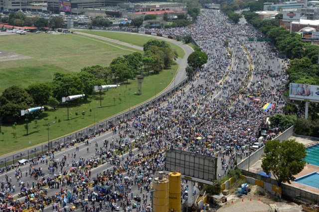 Thousands of Venezuelan opposition activists demonstrate against President Nicolas Maduro in Caracas, on April 24, 2017. Protesters rallied on Monday vowing to block Venezuela's main roads to raise pressure on Maduro after three weeks of deadly unrest that have left 21 people dead. Riot police fired rubber bullets and tear gas to break up one of the first rallies in eastern Caracas early Monday while other groups were gathering elsewhere, the opposition said.  / AFP PHOTO / Federico PARRA