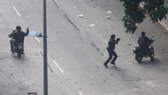 Civiles armados apuntan a manifestantes. R. ROMERO / REUTERS