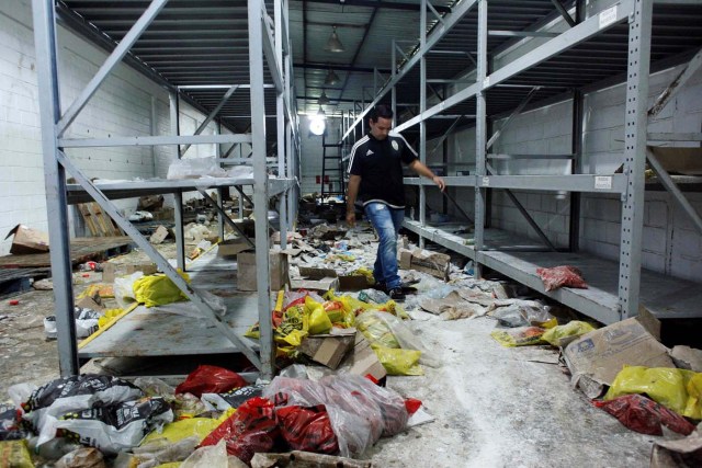 A worker walks among damaged goods in a supermarket after it was looted in San Cristobal, Venezuela May 17, 2017. REUTERS/Carlos Eduardo Ramirez