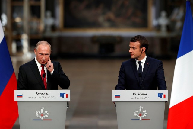 French President Emmanuel Macron (R) and Russian President Vladimir Putin (L) react during a joint press conference at the Chateau de Versailles before the opening of an exhibition marking 300 years of diplomatic ties between the two countries in Versailles, France, May 29, 2017. REUTERS/Philippe Wojazer