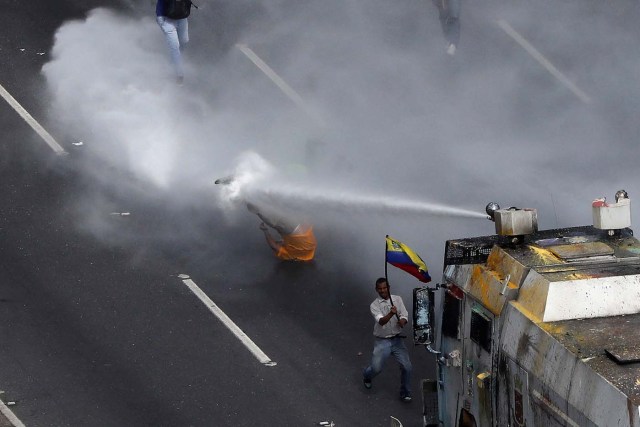 Deputy of the opposition Carlos Paparoni is hit by a jet of water during clashes at a march to the state Ombudsman's office in Caracas, Venezuela May 29, 2017. REUTERS/Carlos Garcia Rawlins      TPX IMAGES OF THE DAY