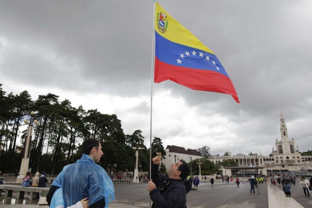 PAC01 FÁTIMA (PORTUGAL), 10/05/2017.- Un peregrino ondea la bandera venezolana en el santuario de Fátima, Portugal, hoy, 10 de mayo de 2017. El papa Francisco afirmó hoy durante la audiencia que en su visita los próximo viernes y sábado al santuario de Fátima pondrá en manos de la Virgen "el destino temporal y eterno de la humanidad". EFE/Paulo Cunha