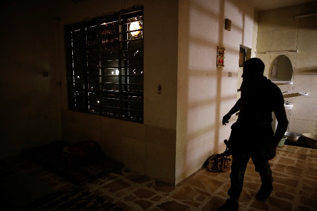 Un soldado del Ejército iraquí inspecciona una habitación usada como celda para mujeres.