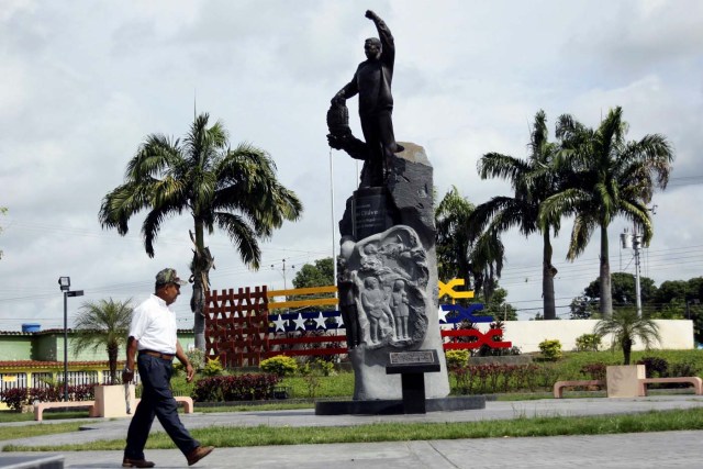 A man walks next to a statue of Venezuela's late President Hugo Chavez in Sabaneta, Venezuela June 13, 2017. Picture taken June 13, 2017. REUTERS/Carlos Eduardo Ramirez
