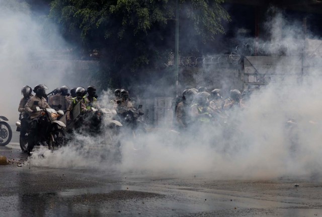 Security forces on motorcycles are seen behind a cloud of tear gas during a rally against Venezuela's President Nicolas Maduro's government in Caracas, Venezuela June 29, 2017. REUTERS/Carlos Garcia Rawlins