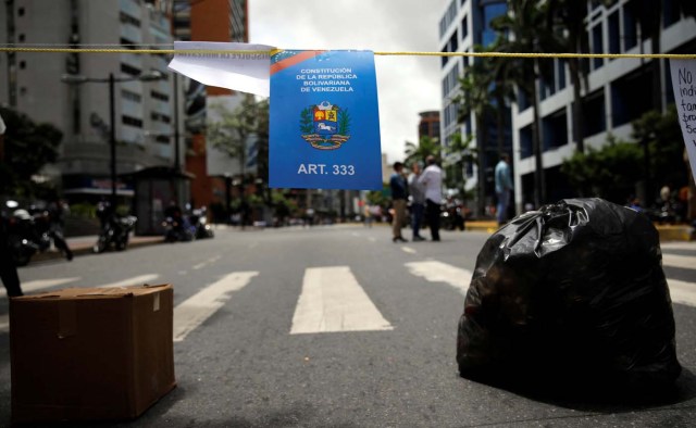 A sign depicting Venezuela's Constitution hangs on a rope at a barricade during a protest against Venezuelan President Nicolas Maduro's government in Caracas, Venezuela July 10, 2017. REUTERS/Carlos Garcia Rawlins