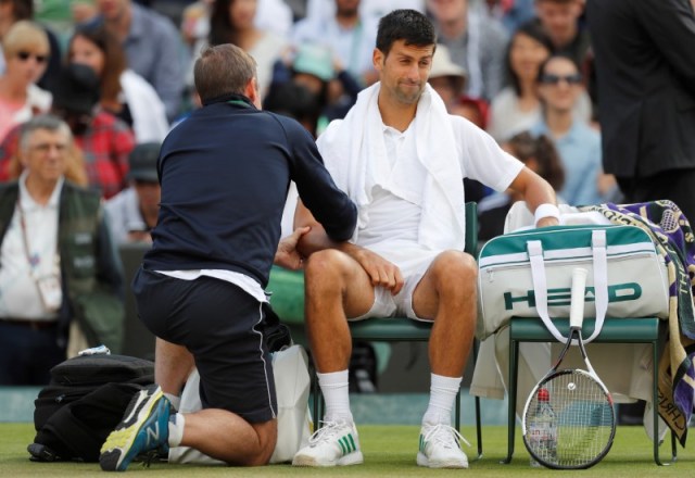 El serbio Novak Djokovic recibe atención médica durante el partido por los cuartos de final de Wimbledon contra el checo Tomas Berdych, en Londres. 12 de julio 2017. REUTERS/Matthew Childs - RTX3B6H7