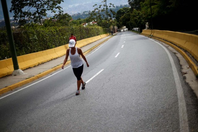 A woman walks along a street during a strike called to protest against Venezuelan President Nicolas Maduro's government in Caracas, Venezuela July 26, 2017. REUTERS/Andres Martinez Casares