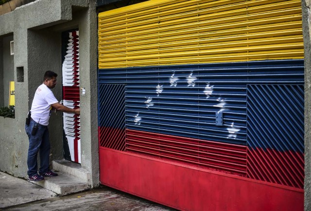 A man stands at the entrance of the house of Venezuelan opposition leader Leopoldo Lopez in Caracas on August 1, 2017 just hours after he was taken away by the intelligence service. The Venezuelan intelligence service arrested opposition leaders Leopoldo Lopez and Antonio Ledezma overnight Monday, relatives said, a day after a vote to choose a much-condemned assembly that supersedes parliament. Lopez and Ledezma were both already under house arrest when they were picked up by the intelligence service known by its in acronym Sebin, the wife of Lopez and children of Ledezma said separately. / AFP PHOTO / Ronaldo SCHEMIDT