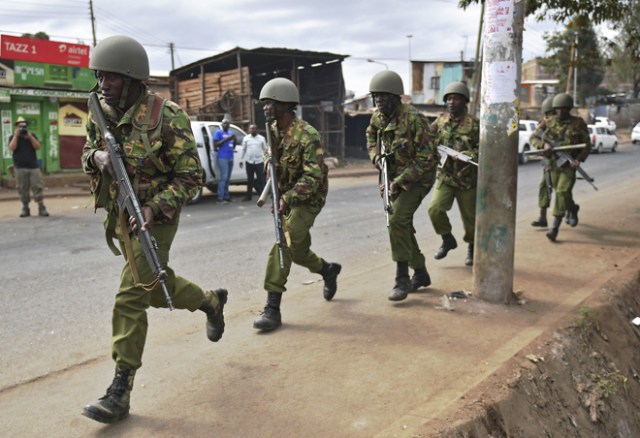 Armed Kenyan police run to disperse protesters in the Kibera slum in Nairobi on August 12, 2017. Three people, including a child, have been shot dead in Kenya during opposition protests which flared for a second day Saturday after the hotly disputed election victory of President Uhuru Kenyatta. Demonstrations and running battles with police broke out in isolated parts of Nairobi slums after anger in opposition strongholds against August 8 election that losing candidate Raila Odinga claims was massively rigged. / AFP PHOTO / CARL DE SOUZA