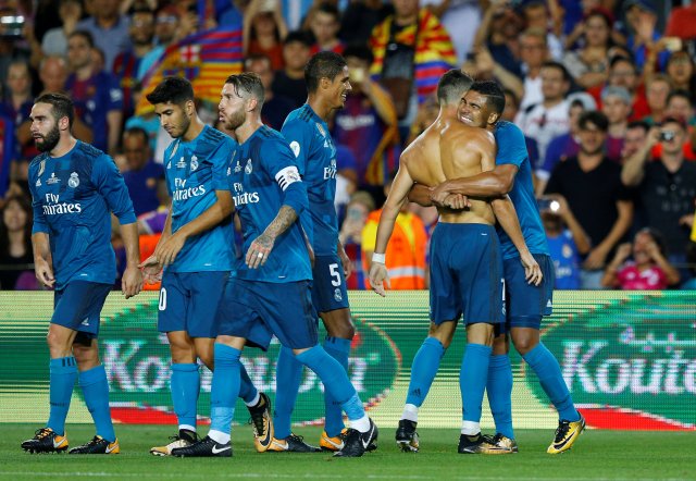 Soccer Football - Barcelona v Real Madrid Spanish Super Cup First Leg - Barcelona, Spain - August 13, 2017   Real Madrid’s Cristiano Ronaldo celebrates scoring their second goal with teammates and is later booked for removing his shirt   REUTERS/Juan Medina