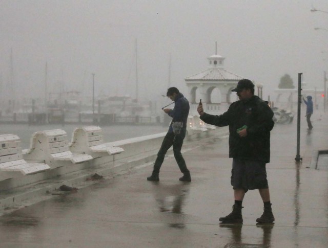 A storm chaser films himself on a camera phone as Hurricane Harvey approaches, on the boardwalk in Corpus Christi, Texas, U.S. August 25, 2017. REUTERS/Adrees Latif