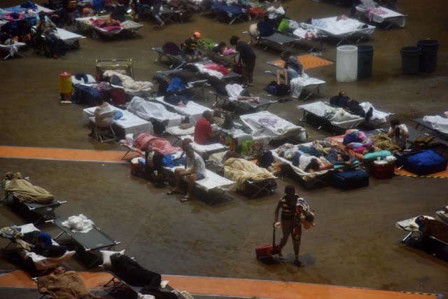 Residents seek shelter inside Roberto Clemente Coliseum in San Juan, Puerto Rico, early on September 20, 2017, as Hurricane Maria passes the island. Hurricane Maria closed in on the Virgin Islands and Puerto Rico on September 20 as forecasters warned of a "potentially catastrophic" storm that has already killed at least two people in the Caribbean. / AFP PHOTO / HECTOR RETAMAL