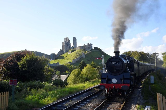 A passenger steam train passes the remains of Corfe Castle as it travels towards Swanage, in Dorset, south west Britain, September 13, 2017. REUTERS/Toby Melville