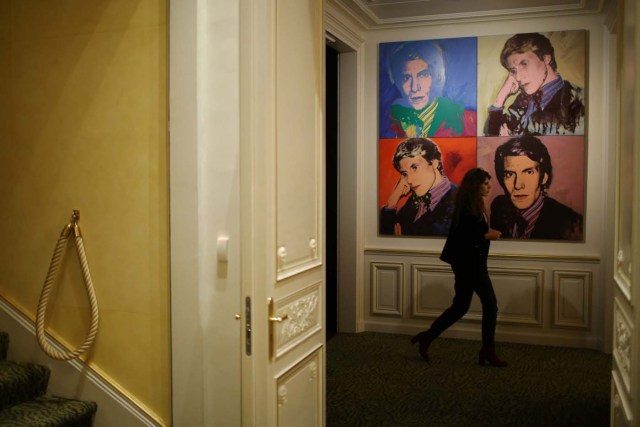 A woman walks past the painting Portrait of Yves Saint Laurent (1974) by Andy Warhol at the Yves Saint Laurent Museum in Paris, France, September 27, 2017. The new museum, celebrating the life and work of French designer Yves Saint Laurent (1936-2008), will open at the avenue Marceau address of his former work studio for almost 30 years. Picture taken September 27, 2017. REUTERS/Stephane Mahe