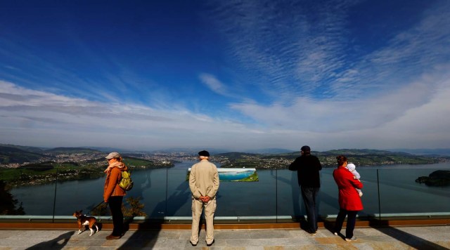 People look over Lake Lucerne from a terrace at the Buergenstock Resort near Lucerne, Switzerland September 28, 2017. REUTERS/Arnd Wiegmann