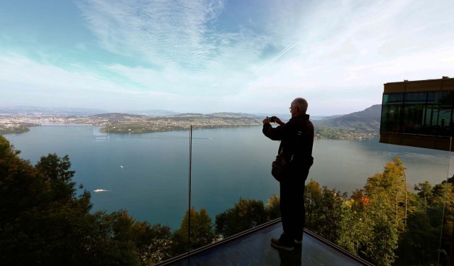 A man takes a picture of Lake Lucerne from a terrace at the Buergenstock Resort near Lucerne, Switzerland September 28, 2017. REUTERS/Arnd Wiegmann