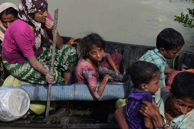 Rohingya refugees arrive on a boat after crossing the Naf river from Myanmar into Bangladesh in Whaikhyang on October 9, 2017. A top UN official said on October 7 Bangladesh's plan to build the world's biggest refugee camp for 800,000-plus Rohingya Muslims was dangerous because overcrowding could heighten the risks of deadly diseases spreading quickly. The arrival of more than half a million Rohingya refugees who have fled an army crackdown in Myanmar's troubled Rakhine state since August 25 has put an immense strain on already packed camps in Bangladesh. / AFP PHOTO / INDRANIL MUKHERJEE