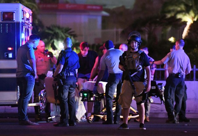 LAS VEGAS, NV - OCTOBER 02: Police officers stand by as medical personnel tend to a person on Tropicana Ave. near Las Vegas Boulevard after a mass shooting at a country music festival nearby on October 2, 2017 in Las Vegas, Nevada .A gunman has opened fire on a music festival in Las Vegas, leaving over 20 people dead. Police have confirmed that one suspect has been shot. The investigation is ongoing.   Ethan Miller/Getty Images/AFP