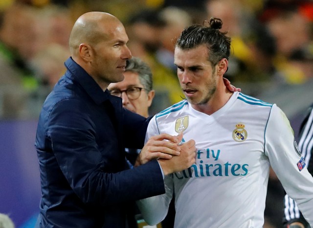 El entrenador del Real Madrid, Zinedine Zidane, da la mano a Gareth Bale tras un cambio en un partido contra el Borussia Dortmund en el estadio Westfalenstadion, Dortmund, Alemania, el 26 de septiembre de 2017. REUTERS/Wolfgang Rattay