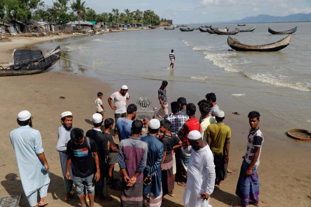 ATTENTION EDITORS - VISUAL COVERAGE OF SCENES OF INJURY OR DEATH Local residents gather around bodies of Rohingya refugee children from Myanmar who were killed when their boat capsized on the way to Bangladesh, in Shah Porir Dwip, in Teknaf, near Cox's Bazar in Bangladesh October 9, 2017. REUTERS/Damir Sagolj TEMPLATE OUT