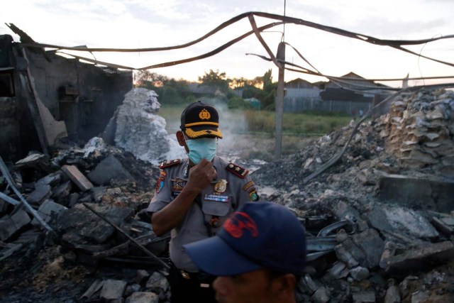 Policemen stand at the site of an explosion at a fireworks factory at Kosambi village in Tangerang, Indonesia Banten province, October 26, 2017. REUTERS/Beawiharta