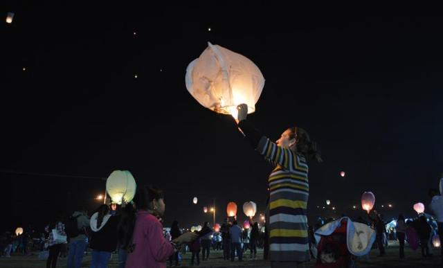 Varias personas lanzan globos de Cantoya, como parte de la iniciativa "Noches Mágicas", hoy, viernes 27 de octubre de 2017, en el poblado de Yuriria, en el estado mexicano de Guanajuato (México). Al caer la noche en Yuriria, este Pueblo Mágico del estado mexicano de Guanajuato se iluminó hoy ante la algarabía y el brillo en las calles de un destino turístico que alberga, entre otros atractivos, la primera gran obra hidráulica colonial de América, una laguna artificial del siglo XVI. EFE/Mario Armas