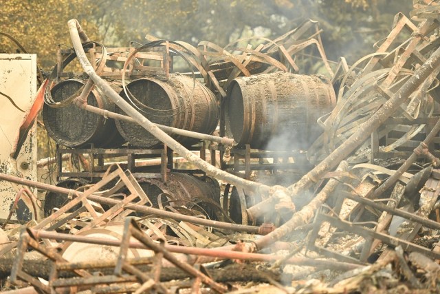 Burned wine barrels are seen at a destroyed Paradise Ridge Winery in Santa Rosa, California on October 10, 2017.  Firefighters encouraged by weakening winds were battling 17 large wildfires on Tuesday in California which have left at least 13 people dead, thousands homeless and ravaged the state's famed wine country. / AFP PHOTO / JOSH EDELSON