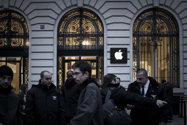 Apple employees stand outside an Apple shop early morning on the release day of the new iPhone X in Paris on November 3, 2017. / AFP PHOTO / PHILIPPE LOPEZ
