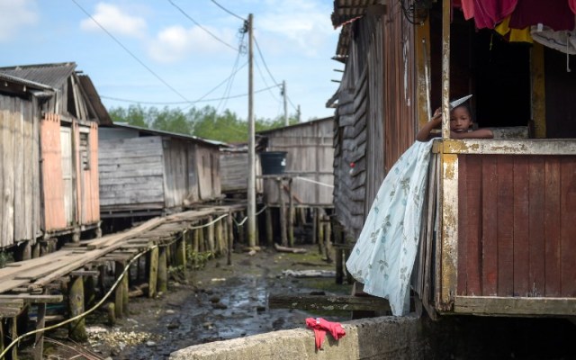 Un niño se encuentra en una casa en City 2000, un barrio de chabolas que alberga a personas desplazadas por guerras territoriales entre bandas criminales en el municipio de Tumaco, departamento de Nariño, Colombia, el 2 de noviembre de 2017. / AFP PHOTO / Raul Arboleda