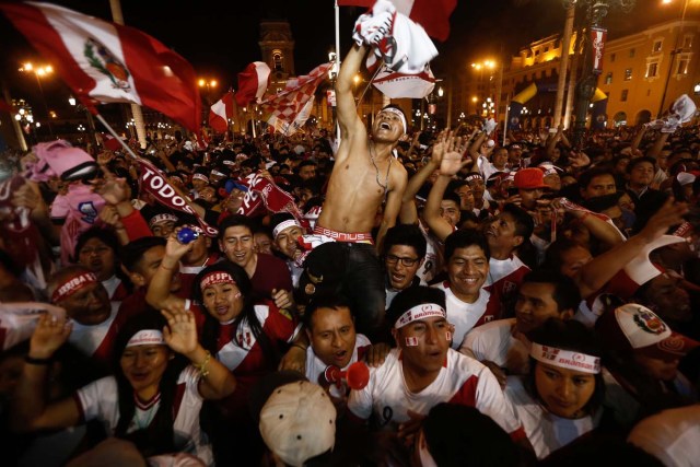 Supporters of Peru celebrate a goal against New Zealand during the 2018 World Cup qualifying play-off second leg football match, at the Plaza Mayor square in Lima, Peru, on November 15, 2017. / AFP PHOTO / STR
