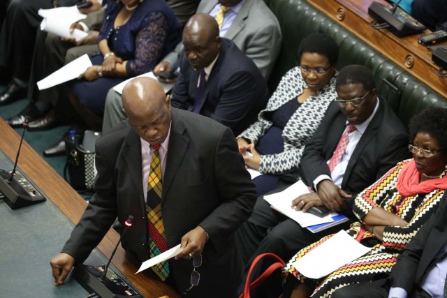 Member of Parliament Patrick Chinamasa (L) moves forward a motion to impeach Zimbabwe President during a parliamentary session on November 21, 2017 at the Zimbabwean Parliament in Harare. Parliament prepares to start impeachment proceedings against the President, while ousted vice president who could be the country's next leader, tells him to step down. As the 93-year-old autocrat faced intensifying pressure to quit, southern Africa's regional bloc announced it was dispatching the presidents of Angola and South Africa to Harare to discuss the crisis. / AFP PHOTO / POOL / AARON UFUMELI