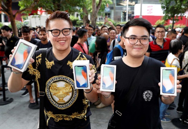 REFILE - ADDING CUSTOMER'S NAME: First customers to buy iPhone X Kittiwat Wang, 22, and Supakorn Rieksiri, also known as Mod, , 22, of Bangkok pose with their iPhone X at the Apple store in Singapore November 3, 2017. REUTERS/Edgar Su