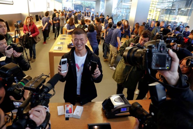 The first customer shows his new iPhone X after buying it at an Apple Store in Beijing, China November 3, 2017. REUTERS/Damir Sagolj