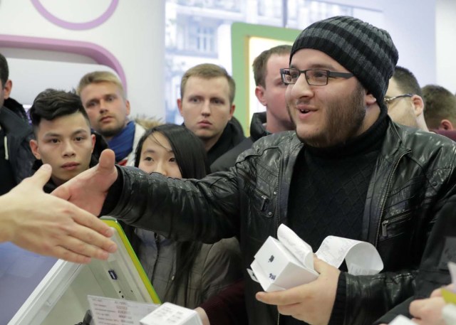 A customer who has just bought Apple's new iPhone X shakes hands with a store employee during its global launch at a cell phone store in central Moscow, Russia November 3, 2017. REUTERS/Tatyana Makeyeva