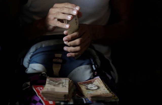 A man counts his money to place horse racing bets at a small warehouse on the outskirts of Caracas, Venezuela, October 7, 2017. REUTERS/Ricardo Moraes SEARCH "MORAES GAMBLING" FOR THIS STORY. SEARCH "WIDER IMAGE" FOR ALL STORIES.