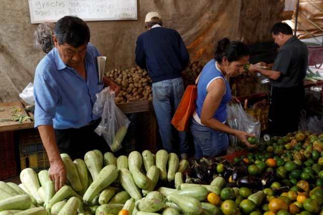 People shop at a vegetable street market in Caracas, Venezuela November 13, 2017. REUTERS/Marco Bello