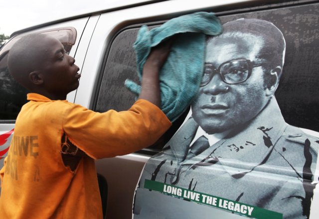 La juventud lava un minibús adornado con la imagen del presidente Robert Mugabe en una terminal de autobuses en Harare, Zimbabwe, el 15 de noviembre de 2017. REUTERS / Philimon Bulawayo NO RESALES. SIN ARCHIVOS