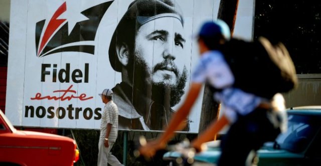 Un hombre pasa frente a un cartel del difunto líder Fidel Castro, en La Habana, Cuba. © Yamil Lage / AFP 